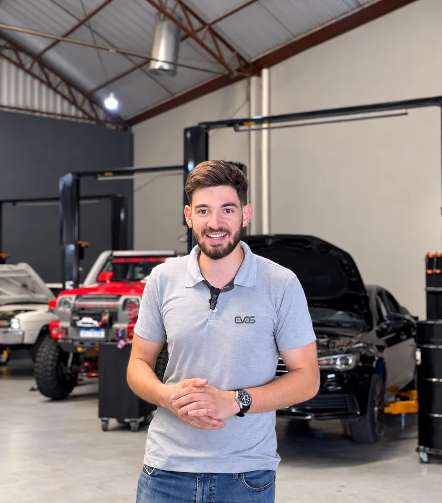 Integrante da equipe Evos Automotive com a camisa da oficina, no galpão do Novo Mundo